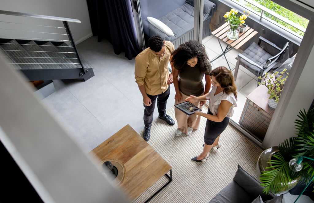 Couple discussing details of a house with their real estate agent while looking at a brochure